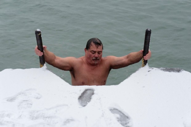 "The Great Lake Jumper" Dan O'Conor emerges from the frigid waters of Lake Michigan after jumping into the lake, as he does every morning, Thursday, Jan. 26, 2023, in Chicago. O'Conor has jumped every day since June 2020. Celebrities and regular folk are plunging into frigid water for their social media feeds, but the science on the supposed benefits is lukewarm. (AP Photo/Erin Hooley)