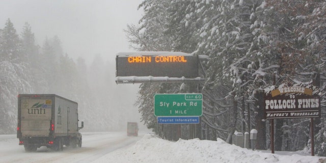 Eastbound Highway 50 requires chain control on vehicles as snow falls in Pollock Pines, Calif., Tuesday, Feb. 28, 2023.