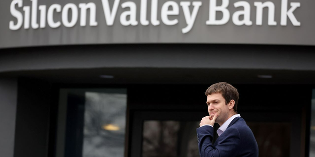 A customer stands outside a shuttered Silicon Valley Bank (SVB) headquarters on March 10, 2023 in Santa Clara, California