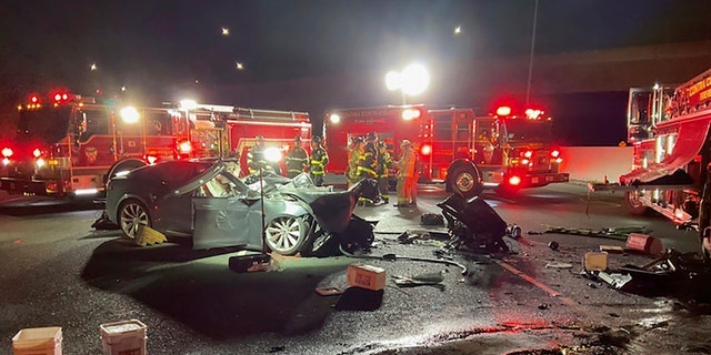 In this photo released by Contra Costa County Fire Protection District, firefighters work the scene of a fatal accident involving a Tesla and Contra Costa County fire truck early Saturday morning, Feb. 18, 2023, in Contra Costa, Calif.  Fire officials said the Tesla driver was killed, and a passenger was critically injured Saturday when the car plowed into the fire truck parked on a Northern California freeway to shield a crew clearing another accident.