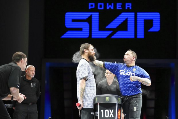 Travis Aragon slaps Jon Kennedy at a Power Slap event in Rio De Janiero, Brazil on Nov. 30, 2022. Power Slap fights are typically three to five rounds. The fighters take turns hitting each other in the face with an open hand, and those on the receiving end stand with their hands behind their backs. (Mike Roach/Sciaffo LLC via AP)