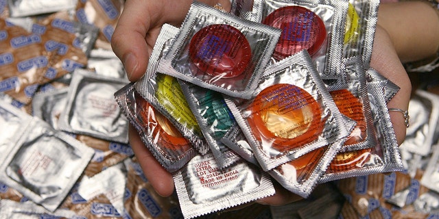 FILE - Katie Freitas, 22, a senior at Stonehill College, shows off condoms that she distributes to other students, Wednesday, March 4, 2009, in Easton, Massachusetts. 