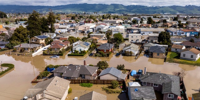 Floodwaters surround homes and vehicles in the community of Pajaro in Monterey County, Calif., on Monday, March 13, 2023. 