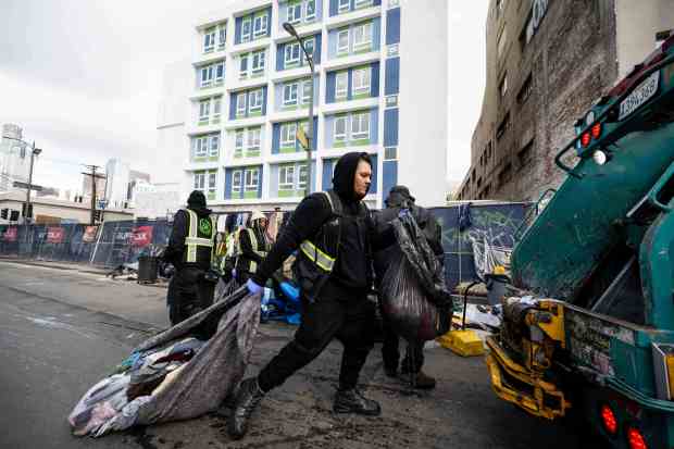 Urban Alchemy and the sanitation department clean up the street across from the Midnight Mission in Los Angeles' skid row on Monday, December 12, 2022. LA Mayor Karen Bass declared a state of emergency on homelessness as her first act as mayor on Monday. (Photo by Sarah Reingewirtz, Los Angeles Daily News/SCNG)