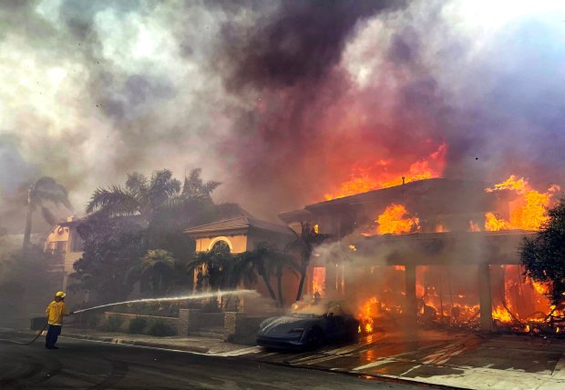 A lone fire fighter takes on a house engulfed in flames in Laguna Niguel where 20 homes were destroyed and 11 others were damaged in the wind whipped Coastal Fire on Wednesday, May 11, 2022. (Photo by Mindy Schauer, Orange County Register/SCNG)