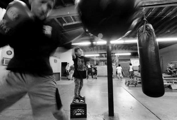 Boxers Noel Corona stands on a create to work on the speed bag as Lorenzo Vasquez, left works the heavy bag while training at M.T.C. Boxing Club in San Bernardino on Monday, October 17, 2022. (Photo by Terry Pierson, The Press-Enterprise/SCNG)