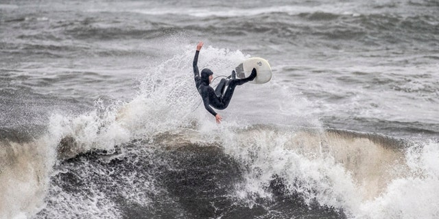 A surfer rides his board at Cowell Beach during the latest atmospheric storm event in Santa Cruz, California, on March 21, 2023. 