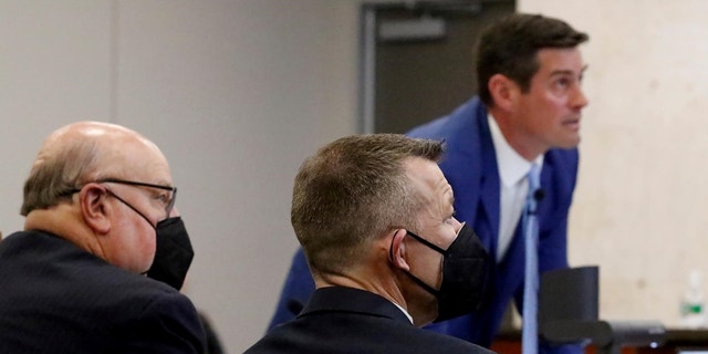 Prosecutor Chris Puervelle puts a slide on a projection screen as defense attorney Paul Sanger, left, and defendant Paul Flores look on in Monterey County Superior Court during the Kristin Smart murder trial. 