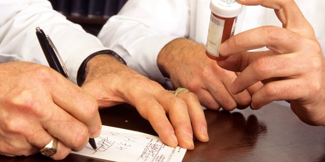 A doctor pens a refill prescription