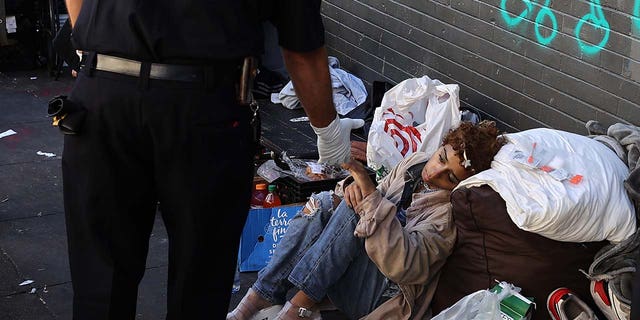 A paramedic helps a homeless woman in the Tenderloin district of San Francisco in California, United States on Oct. 9, 2022. Homelessness and crime have been persistent problems in the Silicon Valley city.