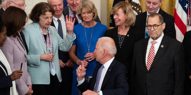 President Biden gestures after US Senator Dianne Feinstein, Democrat of California, raises her hand that she did not receive a commemorate pen after signing H.R. 1652, the VOCA Fix to Sustain the Crime Victims Fund Act of 2021, which redirects monetary penalties to increase funding for victim compensation funds, during a ceremony in the East Room of the White House in Washington, D.C., July 22, 2021.