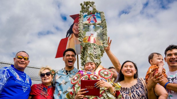 Graduate Theresa Pisona Malaga, center, is weighed down with leis and giant money hat as she is photographed with family following the Loara High School graduation ceremonies in Handel Stadium at Western High School in Anaheim on Thursday, May 25, 2023. (Photo by Leonard Ortiz, Orange County Register/SCNG)