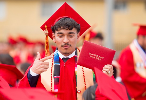 A graduate points out his diploma to fellow graduates during the Loara High School graduation ceremonies in Handel Stadium at Western High School in Anaheim on Thursday, May 25, 2023. (Photo by Leonard Ortiz, Orange County Register/SCNG)