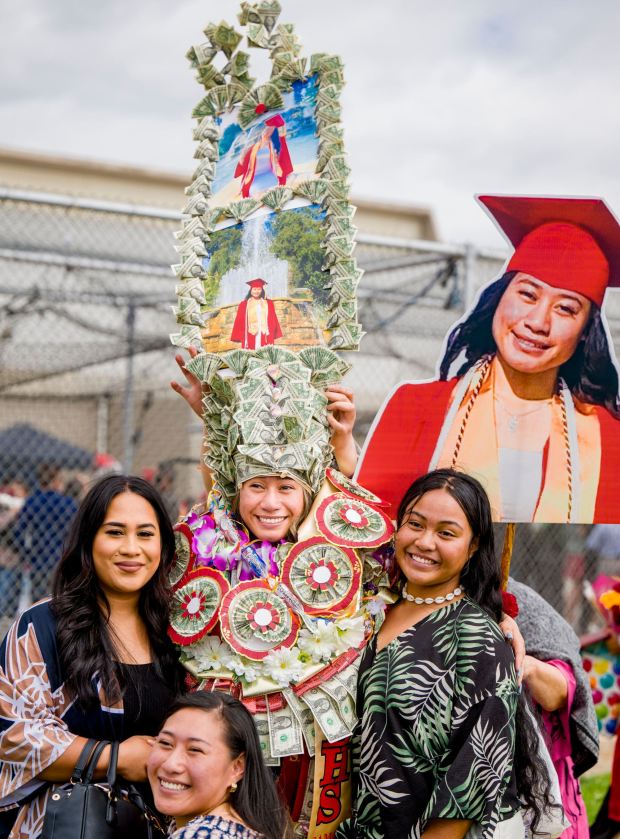 Graduate Theresa Pisona Malaga, center, is weighed down with leis and giant money hat as she is photographed with family following the Loara High School graduation ceremonies in Handel Stadium at Western High School in Anaheim on Thursday, May 25, 2023. (Photo by Leonard Ortiz, Orange County Register/SCNG)