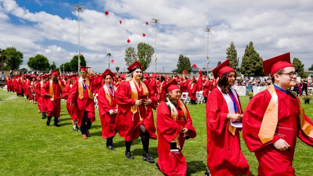 Graduation hats are thrown into the air in the distance as graduates exit Handel Stadium at the conclusion of the Loara High School graduation ceremonies at Western High School in Anaheim on Thursday, May 25, 2023. (Photo by Leonard Ortiz, Orange County Register/SCNG)