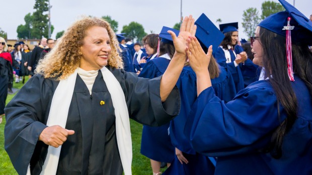 Annamarie Randel-Trejo, left, AUHSD board clerk, high-fives graduates at the conclusion of the Oxford Academy graduation ceremonies in Handel Stadium at Western High School in Anaheim on Tuesday, May 23, 2023. (Photo by Leonard Ortiz, Orange County Register/SCNG)