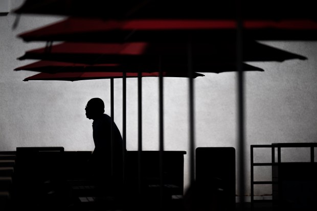 Chick-fil-A employee Blaine Goodman cleans tables under the shade of umbrellas at the restaurant at 1700 E Colorado Blvd in Pasadena Monday, September 26, 2022. (Photo by Hans Gutknecht, Los Angeles Daily News/SCNG)