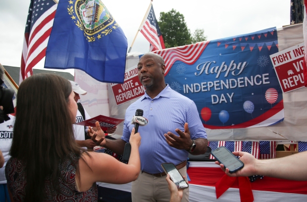 Republican presidential candidate Sen. Tim Scott, R-S.C., speaks to media before walking in the July 4th parade Tuesday, July 4, 2023, in Merrimack, N.H. (AP Photo/Reba Saldanha)