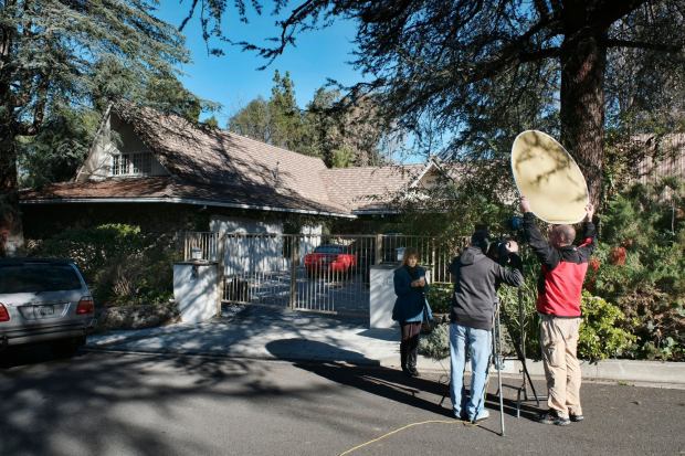 A local news crew reports from a house in the Woodland Hills on Tuesday, Jan. 24, 2017. Homicide detectives are investigating the death of Fabio Sementilli, an internationally known hairdresser and beauty company executive found beaten and stabbed outside his Los Angeles home. Police say paramedics found Sementilli bleeding profusely Monday afternoon at the gated house in the upscale Woodland Hills neighborhood. The 49-year-old suffered multiple stab wounds and died at the scene. (AP Photo/Richard Vogel)