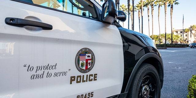 Los Angeles, USA - Close-up on the insignia and slogan of a LAPD vehicle, with the reflection of Union Station's tower visible in the car's window.