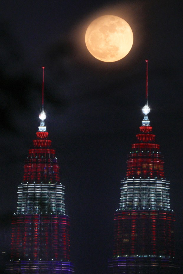 A supermoon rises over Petronas Twin Towers in Kuala Lumpur, Malaysia Thursday, Aug. 31, 2023. The cosmic curtain rose with the second full moon of the month, also known as a blue moon. A little bigger and brighter thanks to its slightly closer position to Earth. (AP Photo/Vincent Thian)