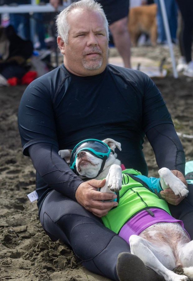 James Wall and his dog Faith collect themselves before competing in the World Dog Surfing Championships, Saturday, Aug. 5, 2023, at Linda Mar Beach in Pacifica, Calif. (Karl Mondon/Bay Area News Group)