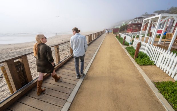 Kate Wheeler, CEO, left, and Austin Barrow, COO, right, of the Crystal Cove Conservancy, walk along the new boardwalk during a tour of the beach-front cottages at Crystal Cove State Park in Newport Beach, on Wednesday, December 6, 2023. (Photo by Mark Rightmire, Orange County Register/SCNG)