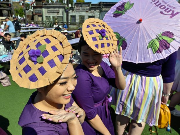 Jazmine Liew, left, and Shannon Kiang don homemade boysenberry pie hats as they head to the Calico Mine Stage to be in a National Boysenberry Day photo at Knott's Berry Farm in Buena Park, CA, on Monday, April 3, 2023. (Photo by Jeff Gritchen, Orange County Register/SCNG)