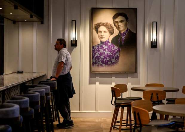 A black and white wedding portrait of Walter and Cordelia Knott with the couple wearing matching boysenberry print outfits boasting a striking splash of purple hangs next to a horseshoe bar between the lobby and the new Thirty Acre Kitchen dining room at the remodeled Knott's Hotel in Buena Park, CA, on Thursday, Feb. 29, 2024. (Photo by Jeff Gritchen, Orange County Register/SCNG)