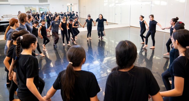 Small Island Big Song performer Yun xe2x80x9cYumaxe2x80x9d Chien, top center, of Taiwan guides students from The Wooden Floor in a dance during a master class in Santa Ana on Friday, Feb. 2, 2024. The Wooden Floor partnered with Chapman Universityxe2x80x99s Musco Center for the Arts to provide six master classes to all The Wooden Floor student, free of charge. ..Small Island Big Song is an artistic collective of singers, musicians, and dancers from island nations in the Indian and Pacific Oceans that perform their traditional dances and songs. Small Island Big Song will be performing at the Musco Center for the Arts on Feb. 3. (Photo by Leonard Ortiz, Orange County Register/SCNG)