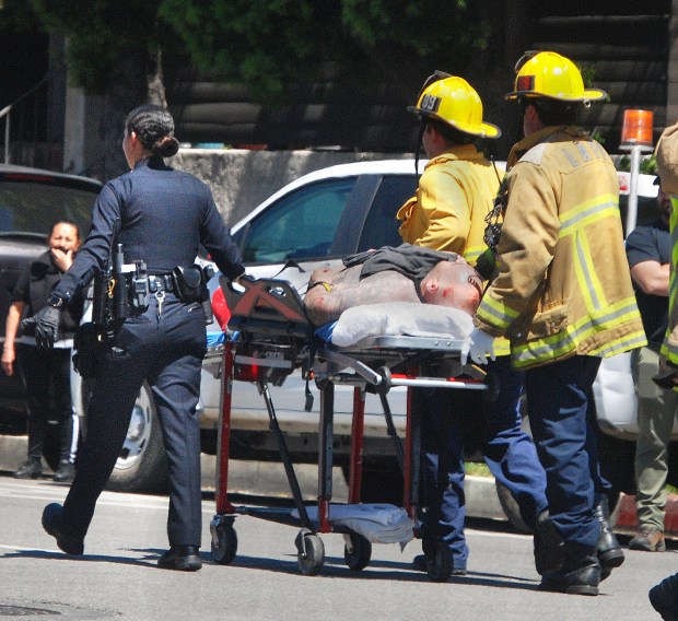 Los Angeles firefighters extinguish a car fire Wednesday, April 10, 2024, on Laurel Canyon Boulevard south of Oxnard Street in Valley Glen after an LAPD pursuit ended with a crash that injured a woman in another vehicle as well as the suspect in this BMW sedan. The injured male suspect was pulled from the burning vehicle by LAPD officers and hospitalized. (Photo by Mike Meadows/Contributing Photographer)