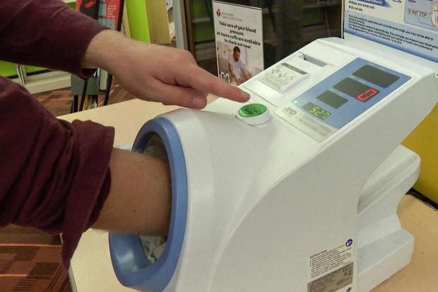 A free blood pressure machine is used at the public library.